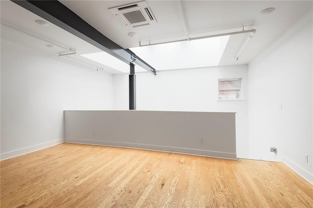 empty room featuring visible vents, baseboards, and wood finished floors