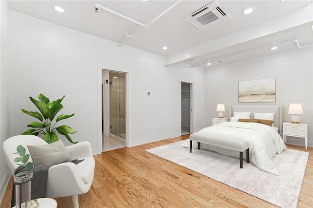 bedroom with visible vents, a walk in closet, ensuite bathroom, recessed lighting, and light wood-style floors