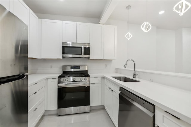 kitchen with white cabinetry, appliances with stainless steel finishes, sink, and pendant lighting