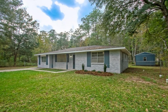 single story home with a front yard and a storage unit