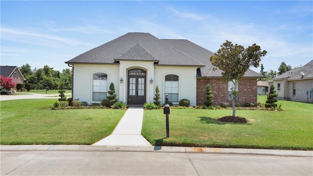 french country inspired facade featuring a front yard