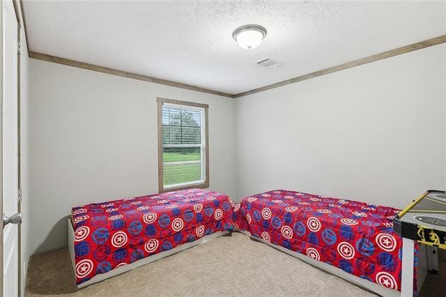 carpeted bedroom with crown molding and a textured ceiling