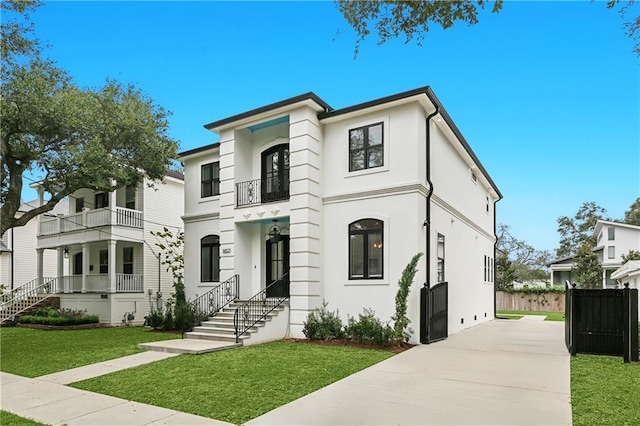 view of front of home with a balcony and a front lawn