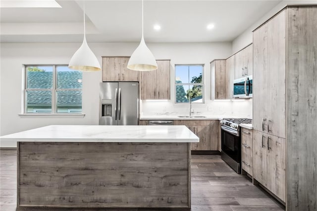 kitchen with pendant lighting, stainless steel appliances, a wealth of natural light, and sink