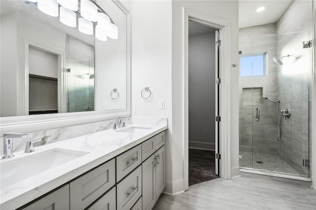 bathroom with vanity, an enclosed shower, and wood-type flooring