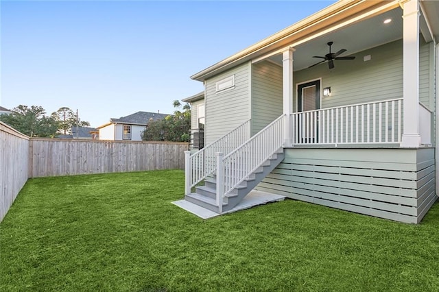 property entrance with ceiling fan and a yard