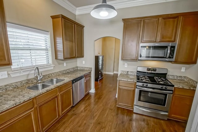 kitchen with sink, light stone counters, dark hardwood / wood-style floors, crown molding, and appliances with stainless steel finishes