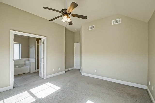 unfurnished bedroom with ceiling fan, lofted ceiling, light carpet, and connected bathroom