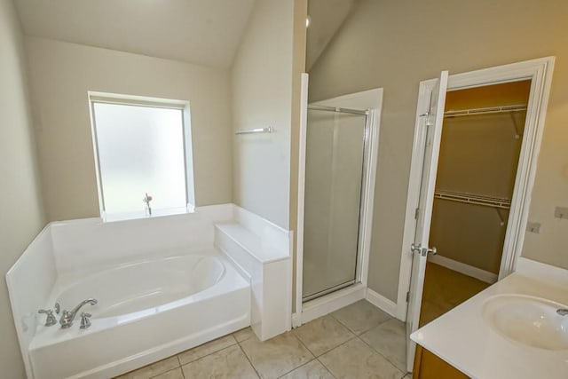 bathroom with tile patterned floors, vanity, separate shower and tub, and lofted ceiling