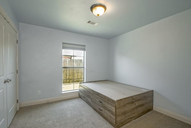 bedroom featuring light colored carpet and a closet