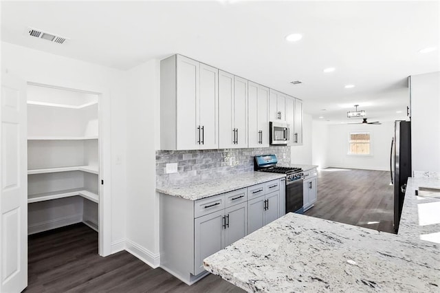 1917 Generes Dr, Harahan, LA 70123 - kitchen with appliances with stainless steel finishes, dark wood finished floors, light stone counters, baseboards, and recessed lighting