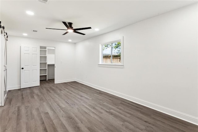 1917 Generes Dr, Harahan, LA 70123 - unfurnished bedroom featuring a barn door, recessed lighting, dark wood finished floors, and baseboards