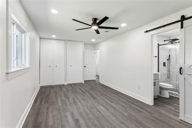 1917 Generes Dr, Harahan, LA 70123 - unfurnished bedroom featuring a barn door, wood finished floors, baseboards, recessed lighting, and a closet