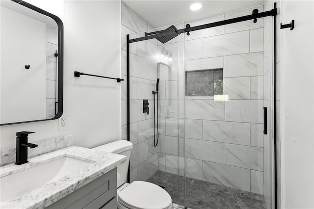 bathroom with vanity, toilet, and a shower with shower door