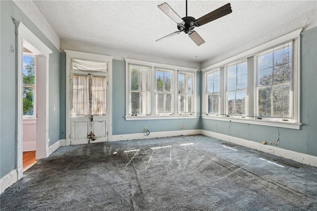 unfurnished sunroom with ceiling fan