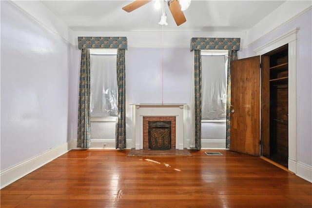 unfurnished living room featuring a fireplace, hardwood / wood-style floors, and ceiling fan