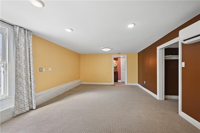 unfurnished room with light carpet and a wall mounted AC