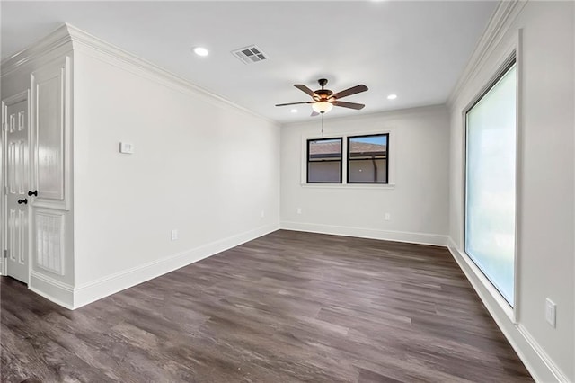 empty room with ceiling fan, dark wood-type flooring, a wealth of natural light, and crown molding