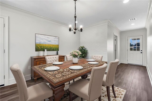 dining room with ornamental molding, dark hardwood / wood-style floors, and a notable chandelier