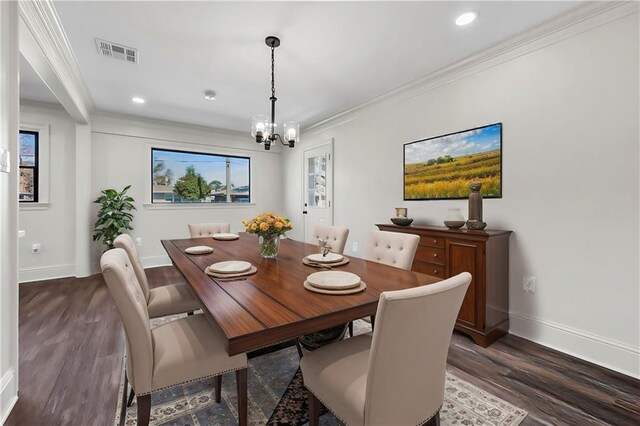 dining room featuring dark hardwood / wood-style flooring, crown molding, and a notable chandelier