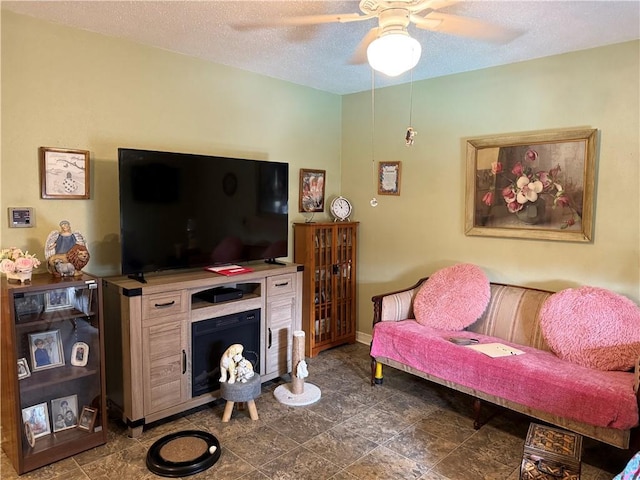 living room with ceiling fan and a textured ceiling