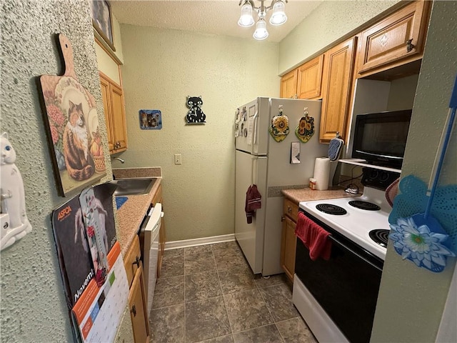 kitchen with a textured ceiling, white appliances, and sink