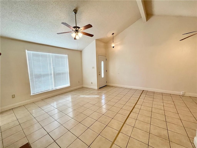 tiled empty room featuring vaulted ceiling with beams, ceiling fan, and a textured ceiling