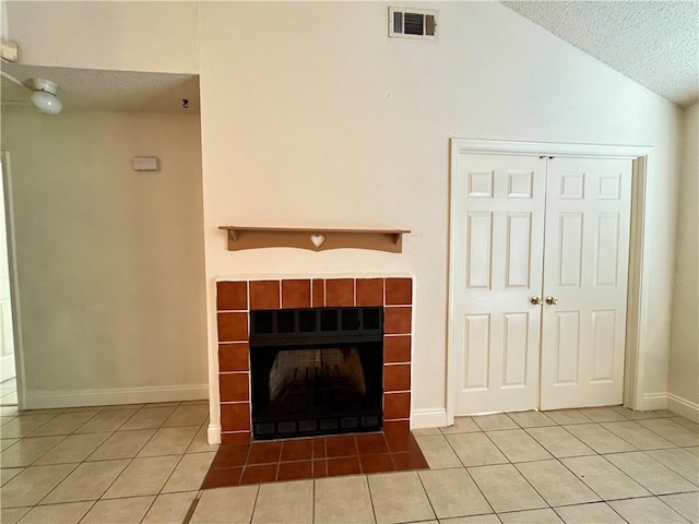 unfurnished living room with tile patterned flooring, a textured ceiling, vaulted ceiling, and a fireplace