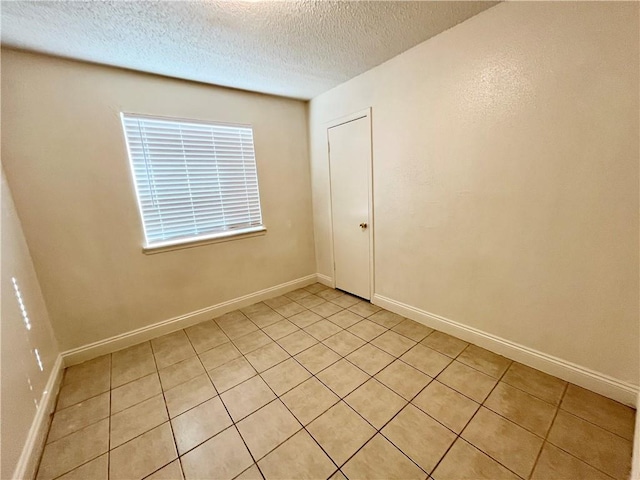 tiled spare room with a textured ceiling