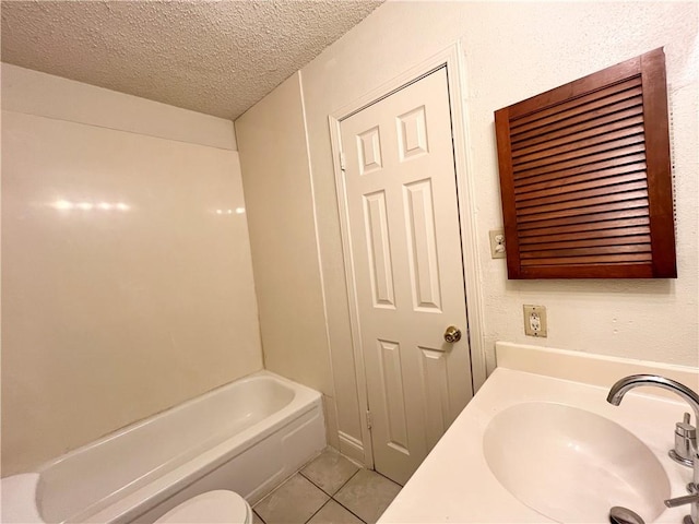 bathroom featuring toilet, a textured ceiling, tile patterned floors, and sink