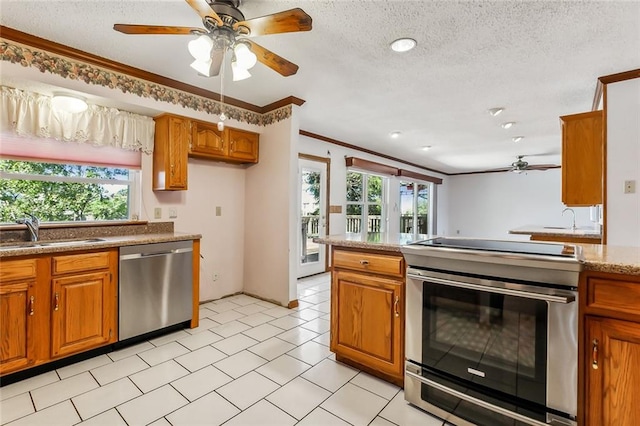 kitchen with stainless steel appliances, plenty of natural light, crown molding, and sink