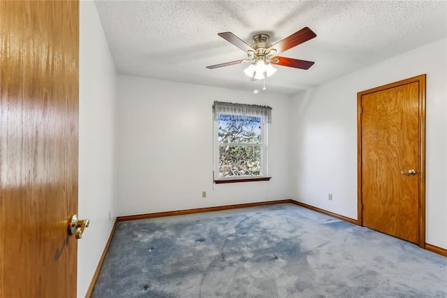 carpeted empty room with ceiling fan and a textured ceiling