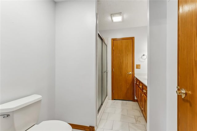 bathroom with tile patterned floors, vanity, toilet, and an enclosed shower