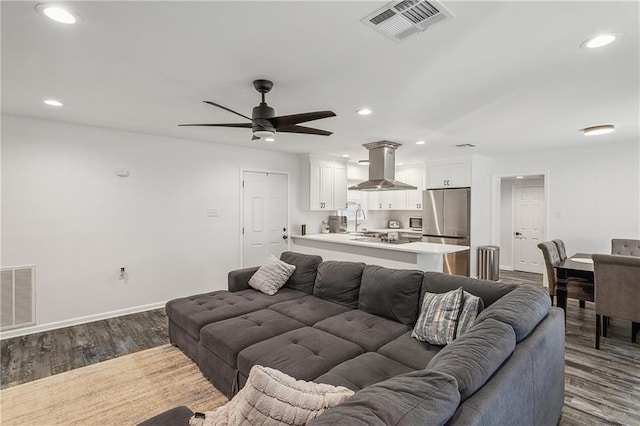 living room featuring ceiling fan, dark hardwood / wood-style flooring, and sink