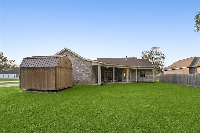 back of house featuring a yard and a shed