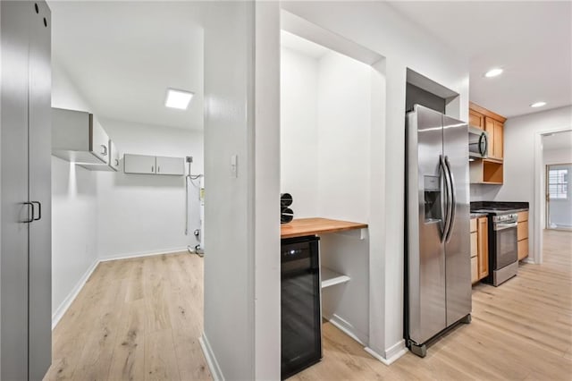 kitchen with butcher block counters, beverage cooler, stainless steel appliances, light hardwood / wood-style flooring, and gray cabinets