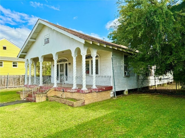 back of house featuring a yard and covered porch