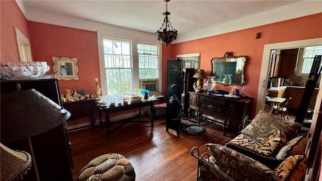 sitting room featuring cooling unit, plenty of natural light, and dark wood-type flooring