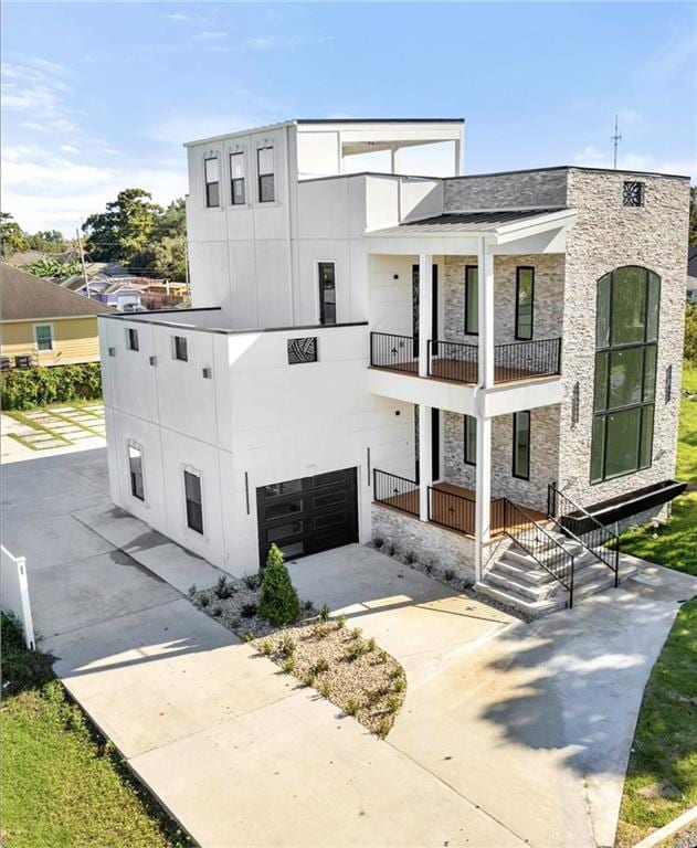 view of front of house featuring a porch, a garage, and a balcony