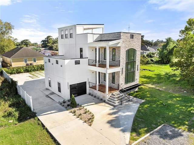 modern home with a front yard, a balcony, and a garage