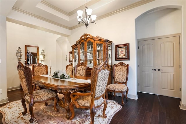 dining room featuring dark hardwood / wood-style flooring, a tray ceiling, crown molding, and a notable chandelier