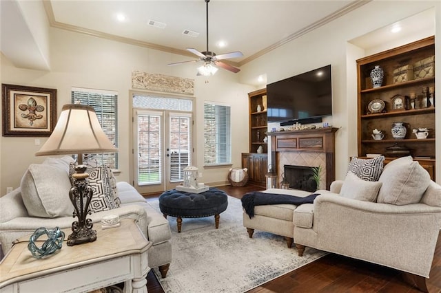 living room featuring a fireplace, hardwood / wood-style flooring, ceiling fan, and crown molding