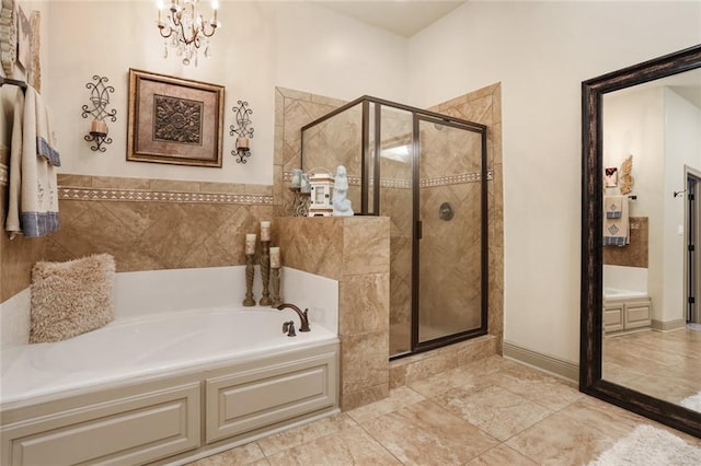 bathroom featuring a notable chandelier and separate shower and tub