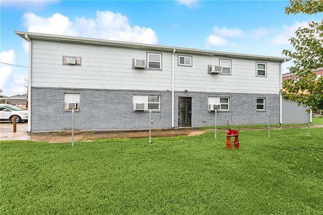 rear view of property featuring an AC wall unit, a yard, and cooling unit