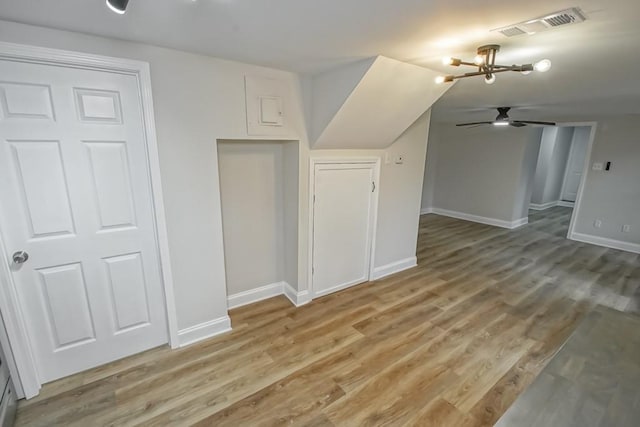 bonus room with hardwood / wood-style flooring and ceiling fan with notable chandelier