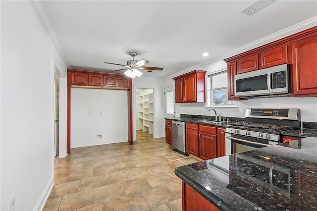 kitchen featuring crown molding, sink, ceiling fan, dark stone countertops, and stainless steel appliances