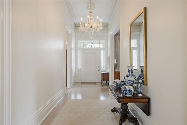 doorway to outside with crown molding and an inviting chandelier