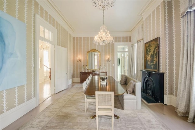 dining room with ornamental molding, a chandelier, and light hardwood / wood-style flooring