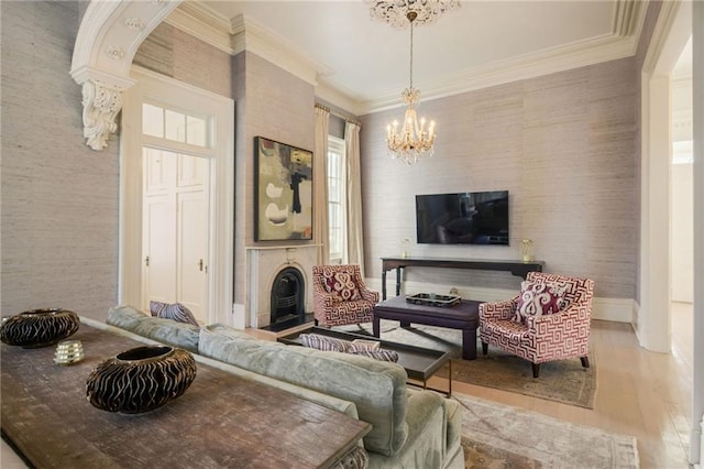 living area with arched walkways, ornamental molding, wood finished floors, a chandelier, and baseboards