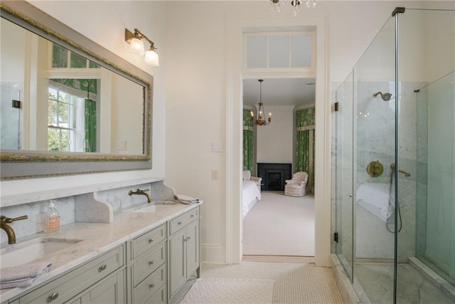 bathroom with vanity, an inviting chandelier, a shower with door, and tile patterned flooring